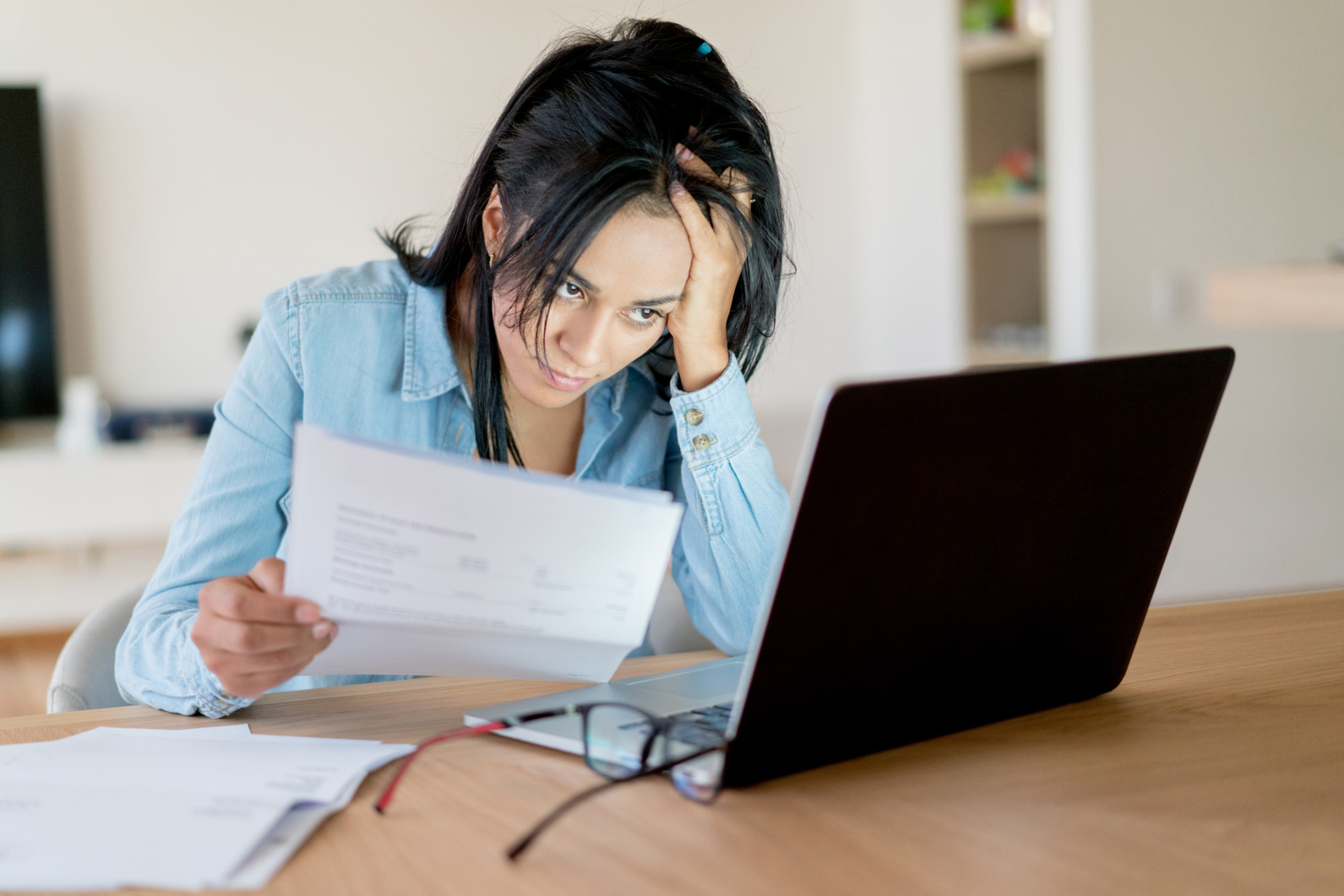 Frustrated woman paying bills online at home